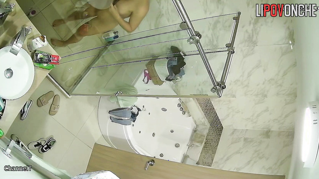 The transparent shower stall does nothing to hide the sexy brunette's naked body