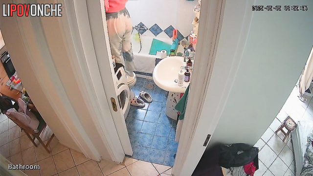 A curious girl looks at her bare bottom while standing on the toilet
