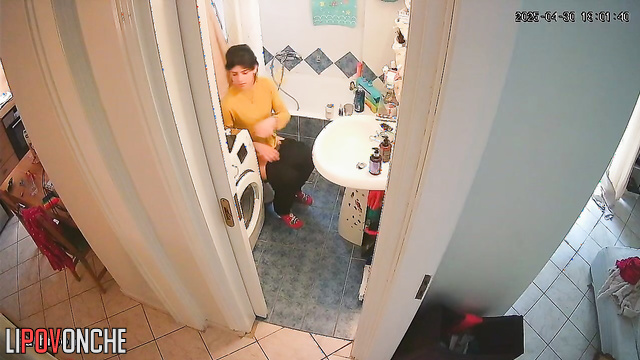A young cutie has her legs up on the sink, sitting on the toilet with her bare ass