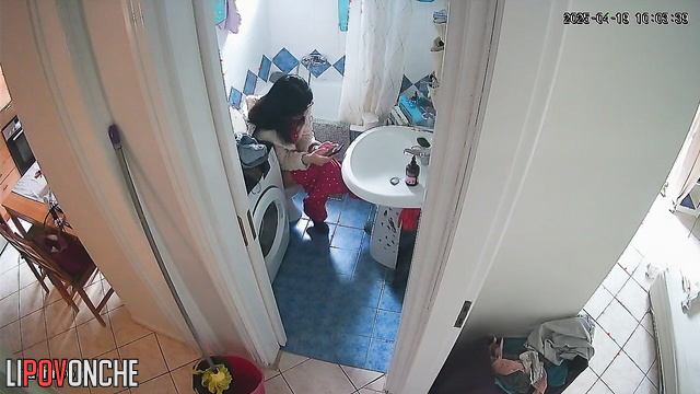 A housewife, sitting right on the toilet, spends a long time washing her butt