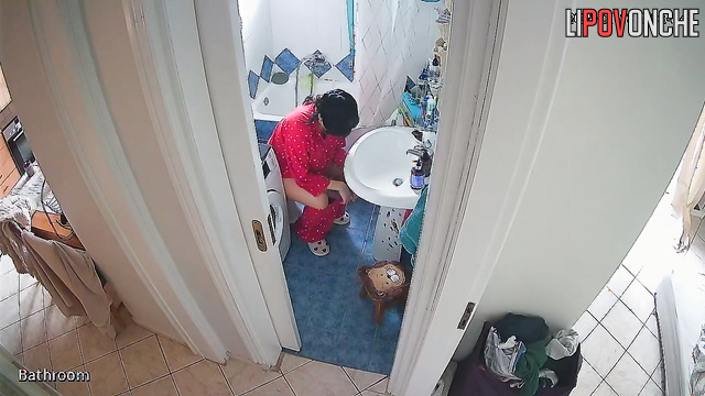 A beauty examines her shaved pussy while sitting on the toilet without panties