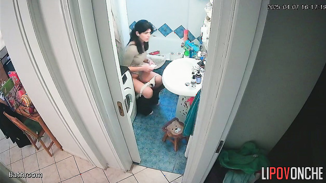 A cute brunette bares her sexy butt and shaved pussy while talking on the phone