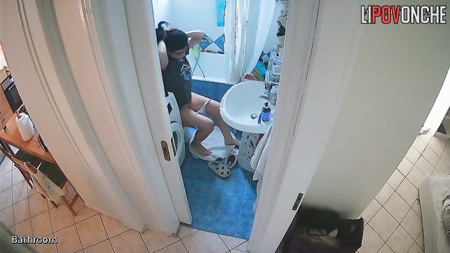 A gorgeous girl in glasses seductively takes off her panties in the bathroom