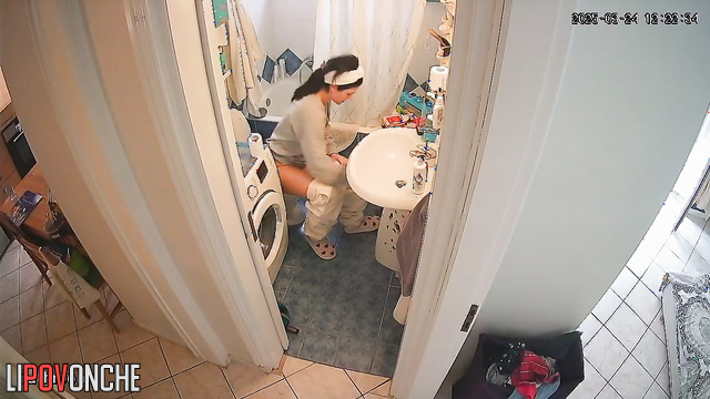 After peeing, the pretty housewife wipes her wet pussy with toilet paper
