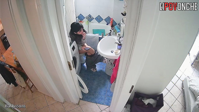 A housewife feeling under the weather sits on the toilet, phone in hand