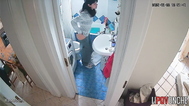 Cutie seductively pulls her pants down over her bottom as she sits down on the toilet