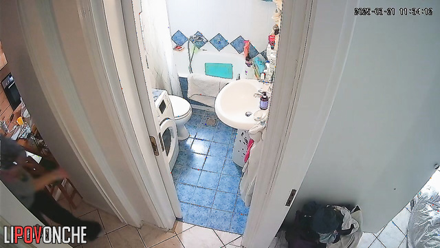 A beautiful girl with her bare ass tidies her hair in the bathroom while peeing