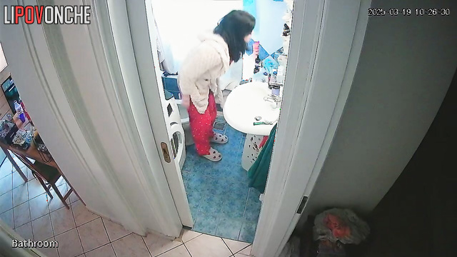 A young housewife brushes her teeth without getting up from the toilet