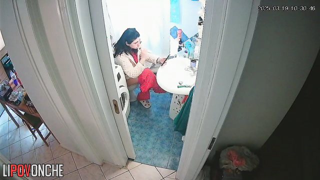A young housewife brushes her teeth without getting up from the toilet