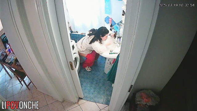 A young housewife brushes her teeth without getting up from the toilet