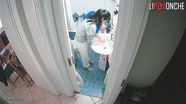 After washing her hands, a delightful cutie pulls down her panties to pee