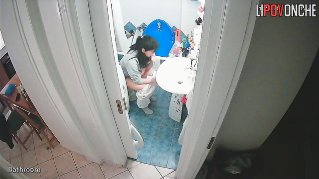 After washing her hands, a delightful cutie pulls down her panties to pee