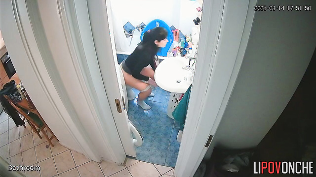 A cute brunette with a sexy ass stands in the restroom with her panties down