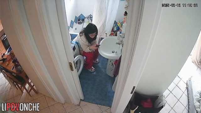 A brunette, sitting on the toilet, lifts her legs high, exposing her bare bottom