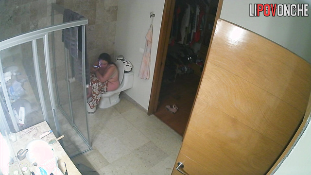 A sexy mommy seductively slips her jumpsuit off her chic body to sit on the toilet