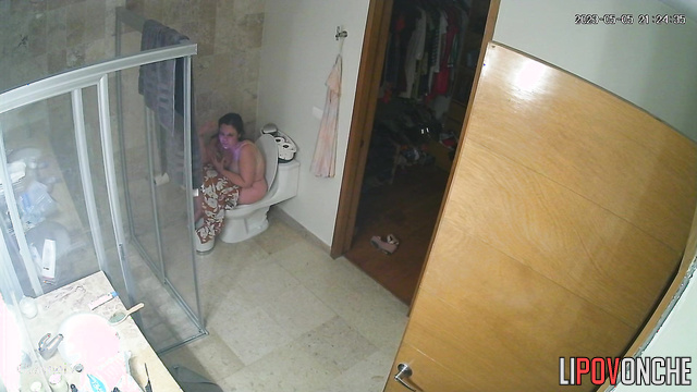 A sexy mommy seductively slips her jumpsuit off her chic body to sit on the toilet