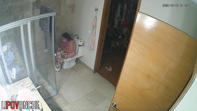 A sexy mommy seductively slips her jumpsuit off her chic body to sit on the toilet