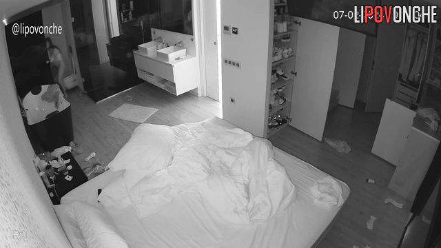 A brunette with a broken arm walks around the bedroom without panties