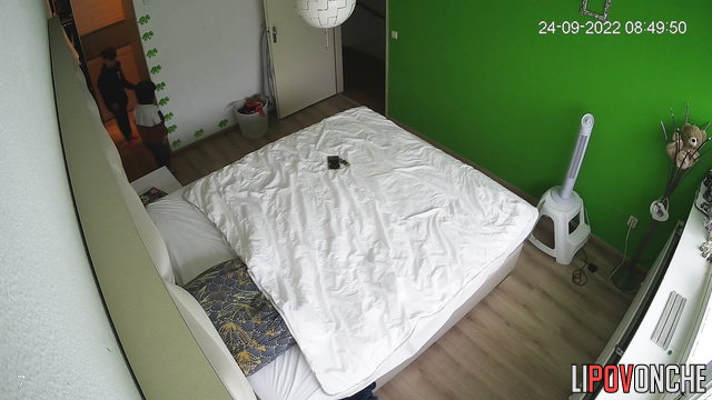 A cute, curly-haired brunette tidies up the bedroom after a wild romp with her lover