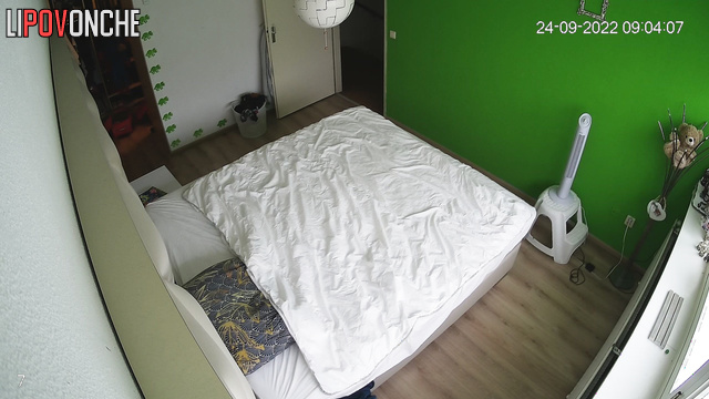 A cute, curly-haired brunette tidies up the bedroom after a wild romp with her lover