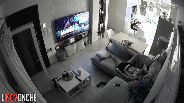 A bored mommy masturbates while watching porn on a big-screen TV