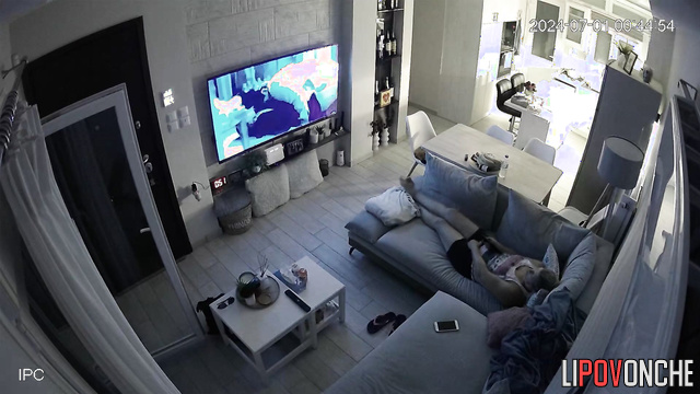 A bored mommy masturbates while watching porn on a big-screen TV