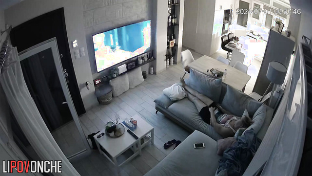 A bored mommy masturbates while watching porn on a big-screen TV