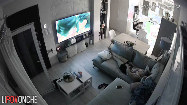 A bored mommy masturbates while watching porn on a big-screen TV