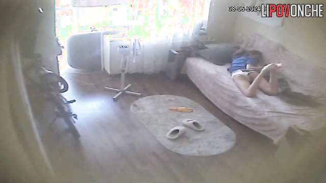 Young brunette chilling with her phone on the sofa