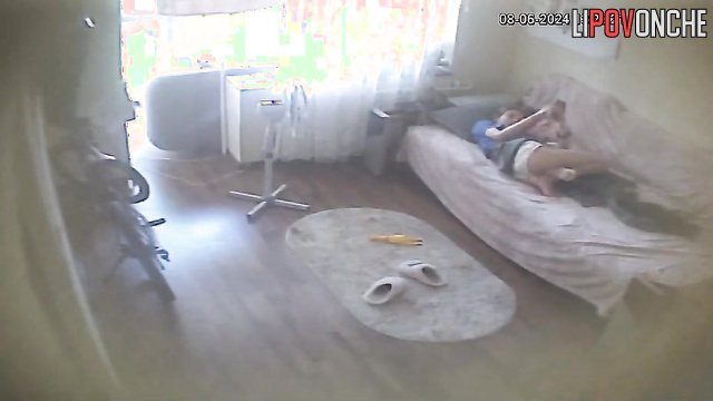 Young brunette chilling with her phone on the sofa