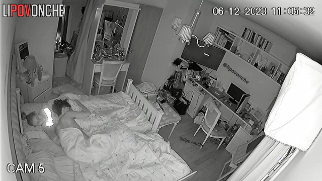 Brother and sister kiss under the blanket while parents are sleeping