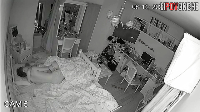 Brother and sister kiss under the blanket while parents are sleeping