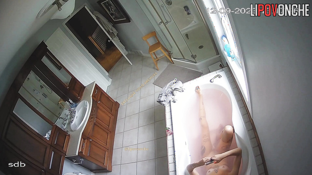 Young tattooed whore chatting with clients in the bathtub