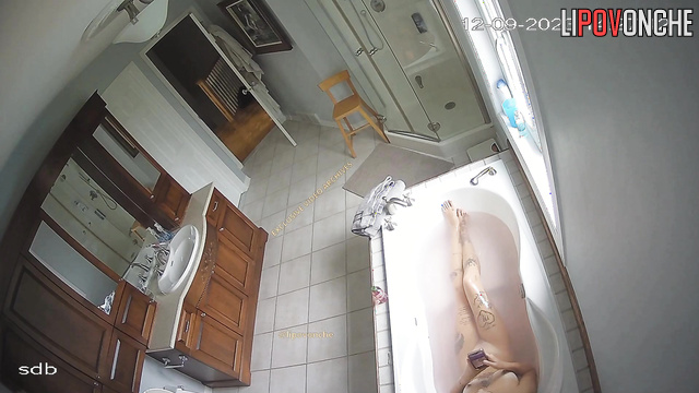 Young tattooed whore chatting with clients in the bathtub