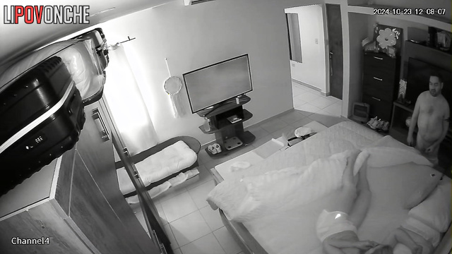A naked man flips through TV channels, waiting for his wife to undress