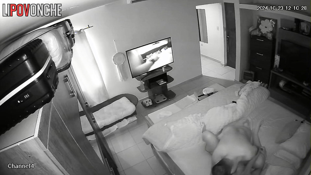 A naked man flips through TV channels, waiting for his wife to undress