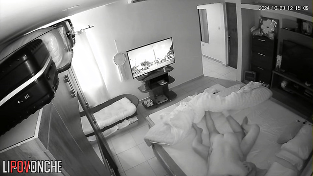 A naked man flips through TV channels, waiting for his wife to undress