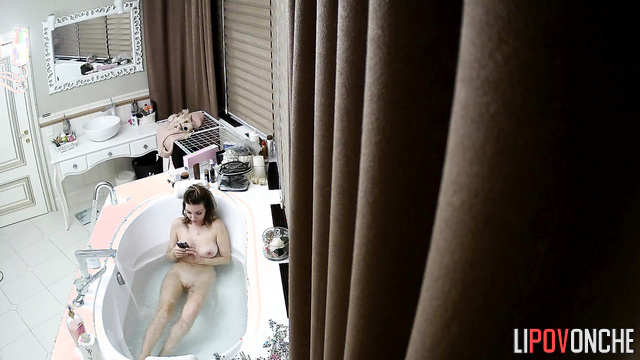 A naked seductive girl pees in the bathtub before taking a bath