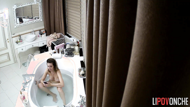 A naked seductive girl pees in the bathtub before taking a bath