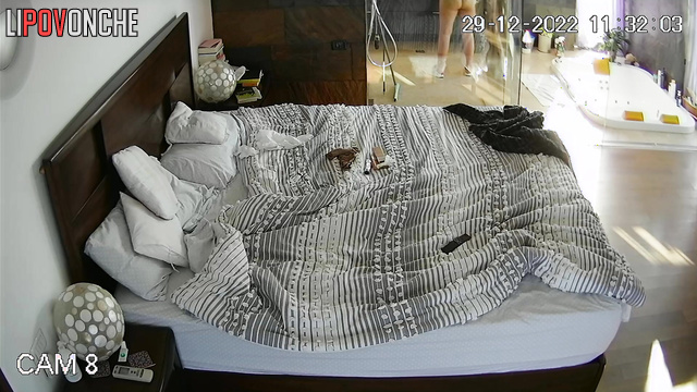 A stunning teacher relaxes in bed with her breasts exposed after showering
