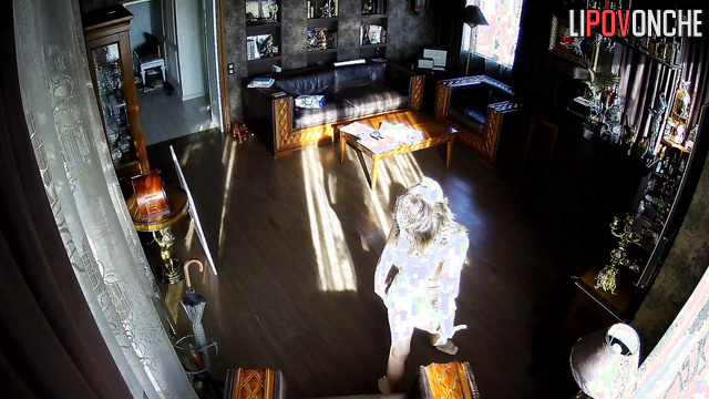 A skinny beauty in a nightgown dances seductively in the middle of the room