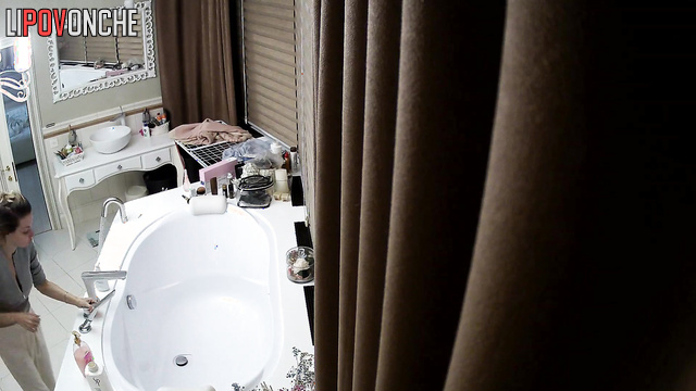 A seductive, slender cutie, completely naked, is bored in the bathtub with her phone