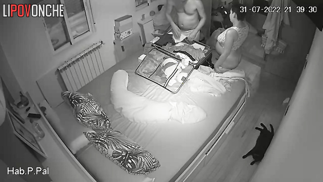 Couple packing a suitcase for a trip (pregnant wife and husband)