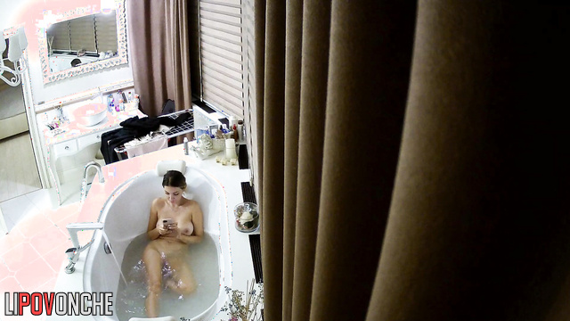 Blonde likes to text while sitting in the bath, look