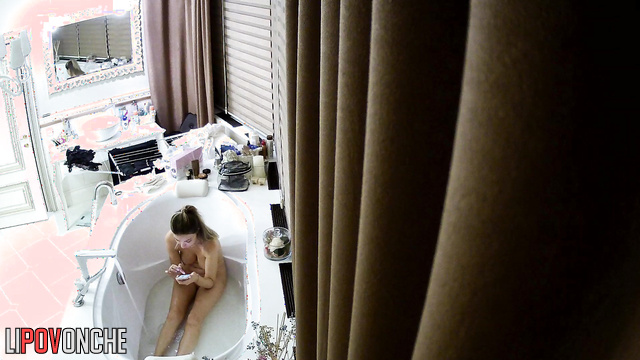 Busty blonde chatting with her boyfriend in a deep bathtub