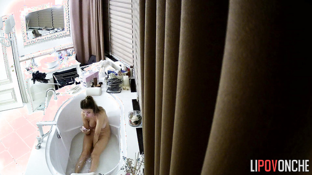Busty blonde chatting with her boyfriend in a deep bathtub