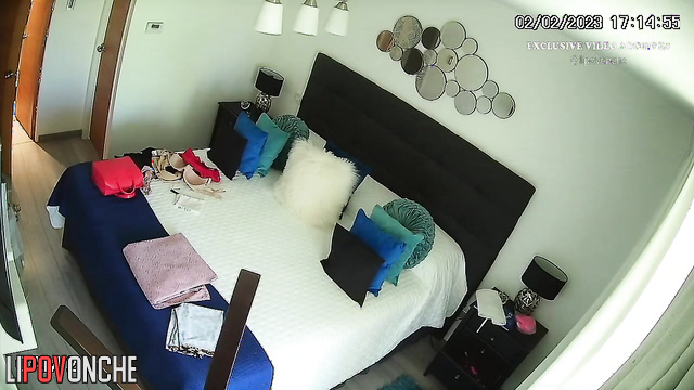 A slim beauty with big boobs seductively undresses in the bedroom