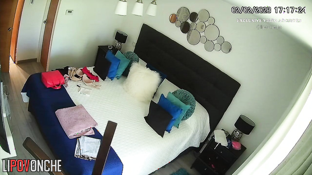 A slim beauty with big boobs seductively undresses in the bedroom
